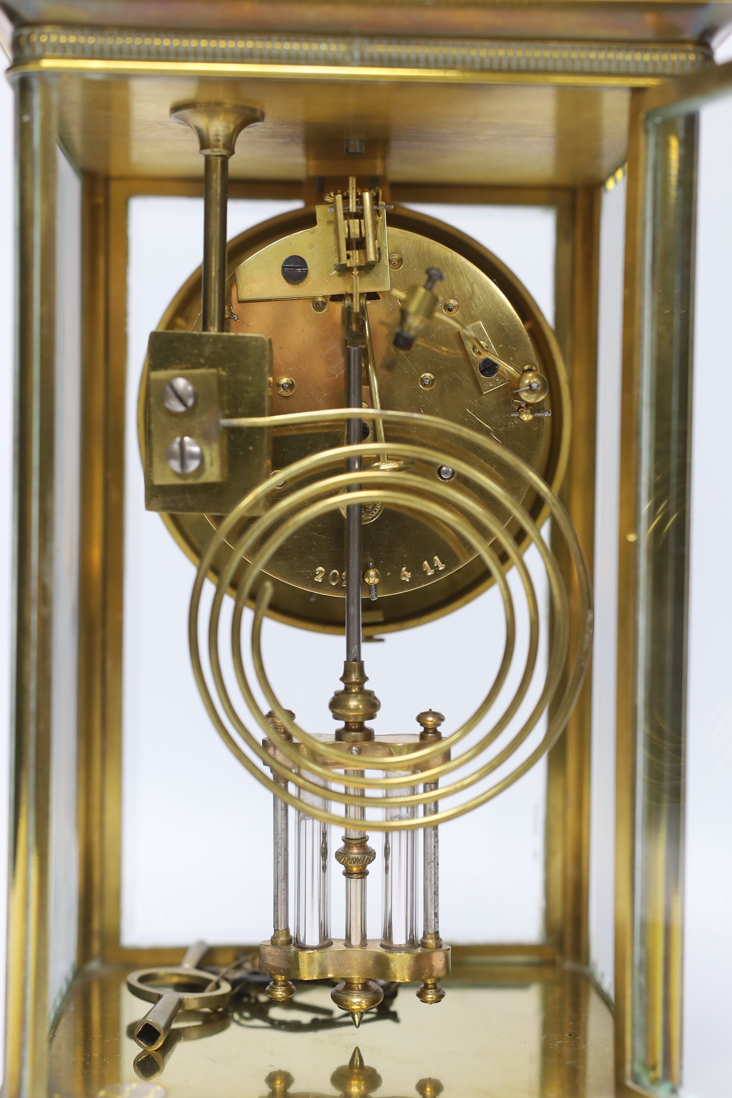 A late 19th century four glass brass clock with key and pendulum, 27cm